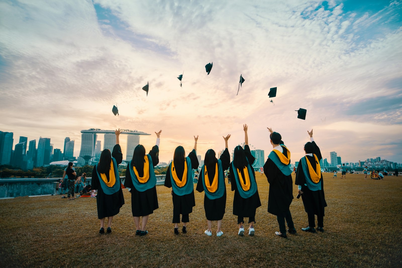Graduates celebrating against a city skyline